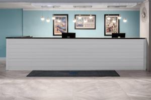 un comptoir blanc dans une pièce avec des photos sur le mur dans l'établissement Coconut Malorie Resort Ocean City, Ascend Collection Hotel, à Ocean City 53 autres photos