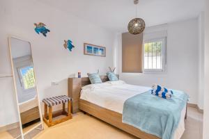 Un dormitorio con una cama grande y un espejo. en Amanda, en Jávea 18 fotos más