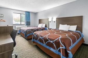 a hotel room with two beds and a desk at Rodeway Inn Delmont in Delmont