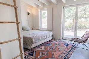 ein Schlafzimmer mit einem Bett, einem Stuhl und einem Teppich in der Unterkunft Casa Acima in São Bartolomeu da Serra + 84 Fotos