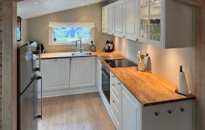 eine Küche mit weißen Schränken und einem Edelstahlkühlschrank in der Unterkunft Three-Bedroom Holiday Home In Vaggerlose in Bøtø By