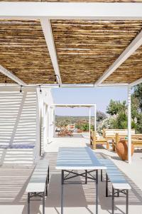 eine Terrasse mit Bänken und einem Holzdach in der Unterkunft Casa Acima in São Bartolomeu da Serra
