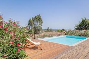 ein Swimmingpool auf einer Holzterrasse mit einem Stuhl neben einem Berater in der Unterkunft Casa Acima in São Bartolomeu da Serra