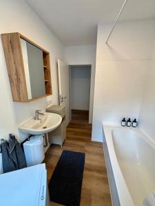 a bathroom with a sink and a bath tub at NEW! StayPfalz Apartment - 3 Zimmer & Parkplatz in Neustadt an der Weinstraße +18 photos