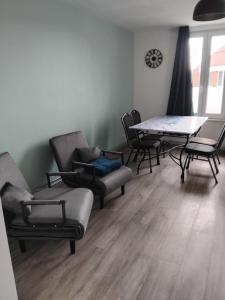 a living room with chairs and a table and a table and chairs at Coriandre La Tisanerie 1 room apartment et lits d appoint in Condé-sur-lʼEscaut