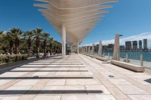 a walkway with a roof over a body of water at Home Trinidad in Málaga
