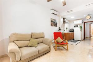 a living room with a couch and a red chair at Home Trinidad in Málaga