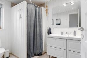 een witte badkamer met een douchegordijn en een wastafel bij TV1695-Jerup-Aaensvej-14 in Bratten Strand +22 foto's