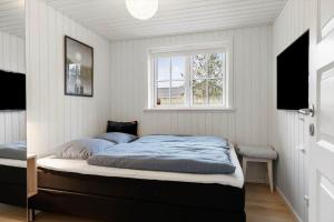een slaapkamer met een bed en een raam bij TV1695-Jerup-Aaensvej-14 in Bratten Strand