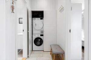 een witte wasruimte met een wasmachine en droger bij TV1695-Jerup-Aaensvej-14 in Bratten Strand