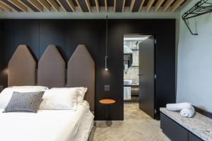 een slaapkamer met een groot bed met een houten hoofdeinde bij Suite Cantina in San Gimignano