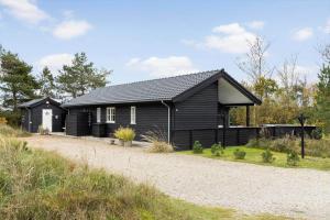 een zwart huis aan de kant van een weg bij TV1695-Jerup-Aaensvej-14 in Bratten Strand