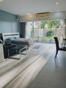 une chambre avec un lit, une table et des chaises dans l'établissement 10 minutes to reach the karon beach, with free swimming pool and gym, WIFI, à Karon Beach