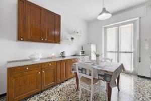 une cuisine avec des placards en bois et une table dans l'établissement Casa Grace - Casa al Mare, à Vado Ligure