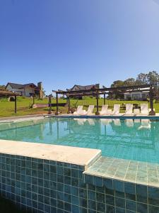 a large swimming pool with lounge chairs at Cabañas La Catalana in Tandil