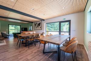 uma sala de jantar com mesas e cadeiras de madeira em Les Chambres d'hôtes Val de Tamié em Faverges