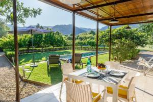 a patio with a table and chairs and a pool at Alfonsa in Pollença