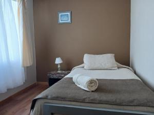 une chambre avec un lit avec une serviette dessus dans l'établissement Casa Cómoda en La Cruz Quillota, à La Cruz