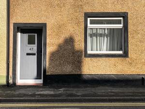 l'ombre d'une personne debout à côté d'une porte dans l'établissement Coast To Coast Cottage, à Cleator Moor
