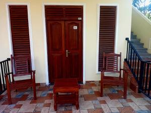 タンガラにあるSunny Side Villaの家の椅子2脚と木製のドア