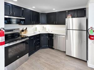 eine Küche mit schwarzen Schränken und einem Kühlschrank aus Edelstahl in der Unterkunft Mt Green 1-D09 in Killington Village