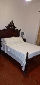 a wooden bed with white sheets and pillows on it at Herdade do Corval in Reguengos de Monsaraz +23 photos