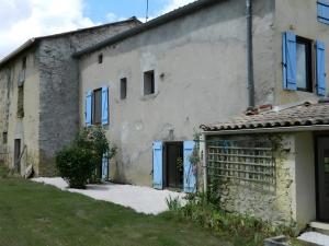 un edificio blanco con persianas azules en Gite Les Cassagnes, 