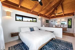 a bedroom with a large bed and a bathroom at Manu O Ku in Kailua-Kona