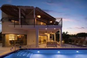a villa with a swimming pool and a house at Ella Sun - Coconut Villa in Eilat