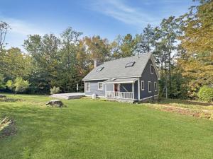 a gray house with a porch in a yard at Hidden Kingdom in Tyson