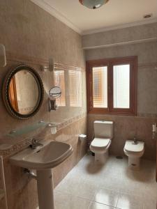 a bathroom with a sink and a toilet and a mirror at Copenhagen Lovely in Gran Tarajal