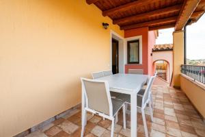 a white table and chairs on a balcony at Villa Tramonto in Villasimius