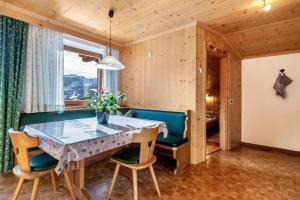 a dining room with a table and chairs at Appartamento Confolia 1 in La Valle +13 photos