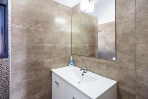 ein Badezimmer mit Waschbecken und Spiegel in der Unterkunft Villa Los Olivares in Roche + 27 Fotos