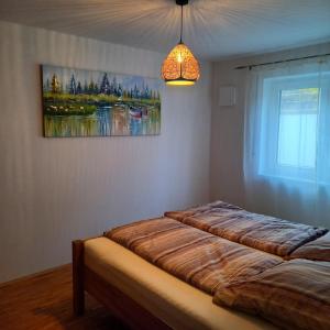 a bedroom with two beds and a painting on the wall at Ferienwohnung Ahornweg in Ihrlerstein +4 photos