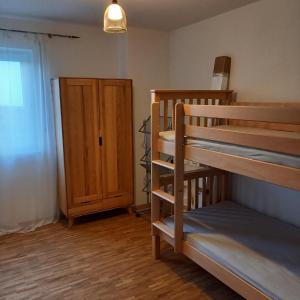 a room with two bunk beds and a wooden door at Ferienwohnung Ahornweg in Ihrlerstein