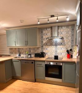 cocina con armarios grises y horno con fogones en Red Deer Cosy Apartment in Letterfrack Connemara, en Letterfrack 28 fotos más