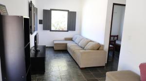 a living room with a couch and a window at Canto das Árvores - Nova União MG in União de Caeté