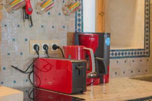 a counter top with a toaster and cups on it at Stella 1 - joli appartement en médina avec cheminée in Essaouira +26 photos
