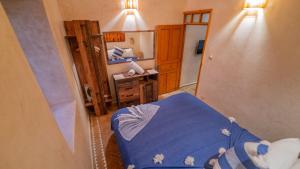 a room with a blue bed and a mirror at Stella 1 - joli appartement en médina avec cheminée in Essaouira