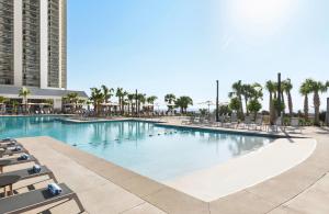 マートルビーチにあるKingston Plantation Condosのヤシの木と椅子が備わる大型スイミングプール