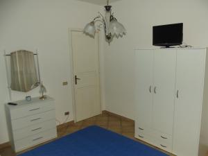 a bedroom with a dresser and a tv on a wall at Appartamento Vacanze Mare in Terrasini
