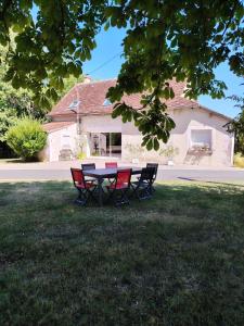 a picnic table in the grass in front of a house at Gite La Nobleterie - 4 personnes Zoo de Beauval 35min in Frédillé +10 photos