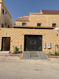 a brick building with a black garage door and stairs at شقة عائلية مودرن 4 غرف نوم رقم 1 in Quai