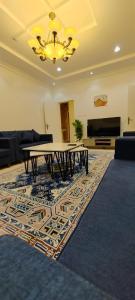 a living room with a table and a rug at شقة عائلية مودرن 4 غرف نوم رقم 1 in Quai