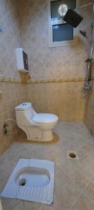 a bathroom with a toilet and a sink at شقة عائلية مودرن 4 غرف نوم رقم 1 in Quai +8 photos