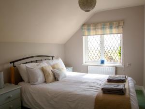 um quarto com uma grande cama branca com duas janelas em Hayloft-E2699 em Winthorpe