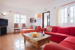 a living room with a red couch and a table at Casa Gegore in Tías
