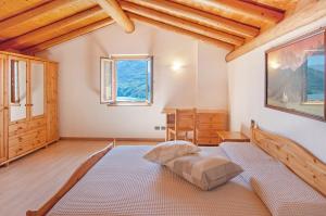 une chambre avec un lit dans une pièce avec des plafonds en bois dans l'établissement Il ciliegio sul lago, à Verceia
