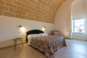a bedroom with a bed and a brick wall at MAGNIFICAT luxury rooms in Matera